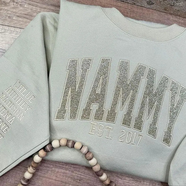 Glitzerndes Mama-Sweatshirt mit gestickter Applikation und Kindernamen auf dem Ärmel