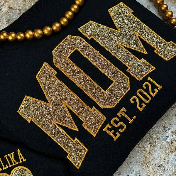 Glitzerndes Mama-Sweatshirt mit gestickter Applikation und Kindernamen auf dem Ärmel